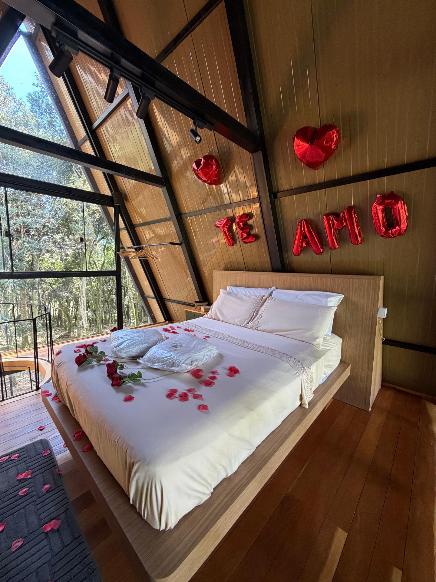 Quarto aconchegante no sótão com roupa de cama de linho e vista para a floresta