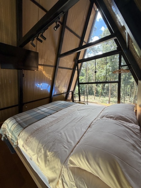 Quarto banhado pela luz natural da floresta